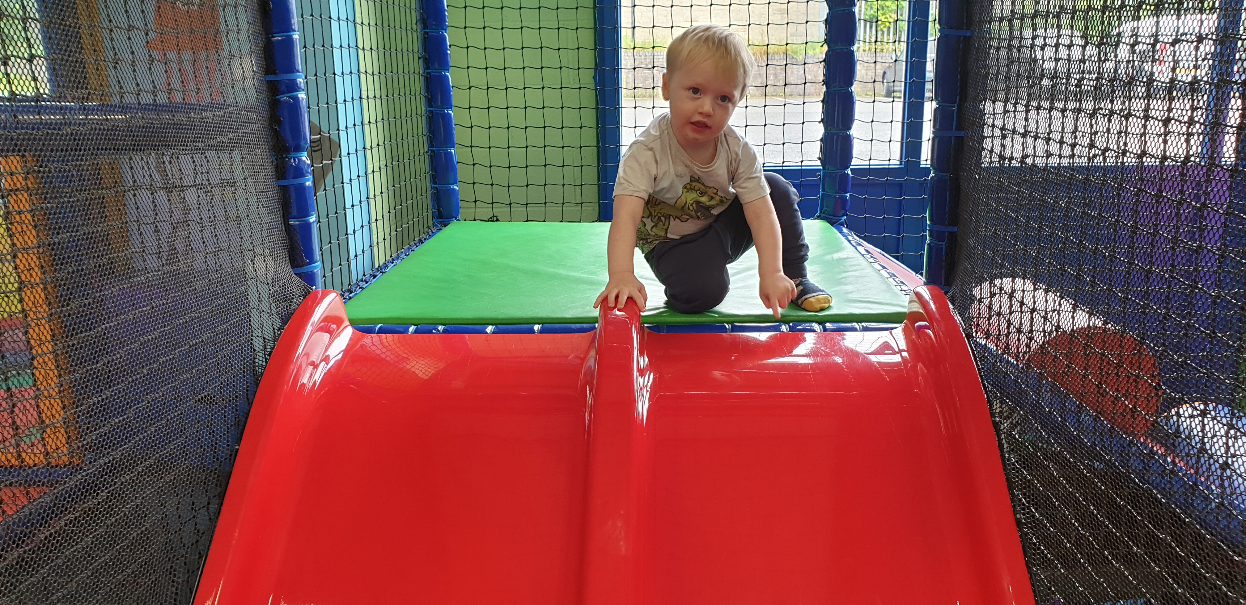 Full image of John prepares to go down a slide.