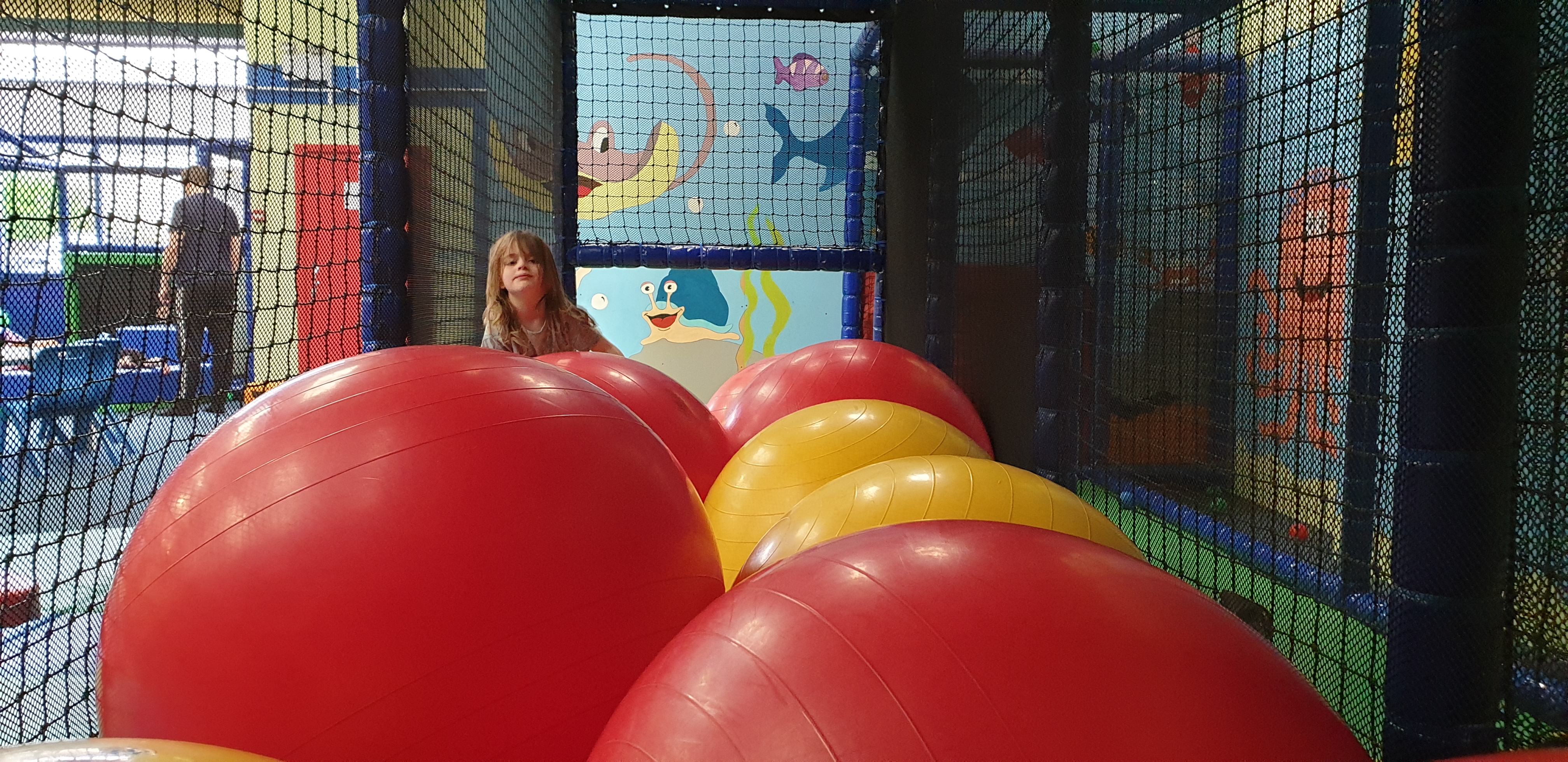 Full image of Annabel peers over the mega balls.