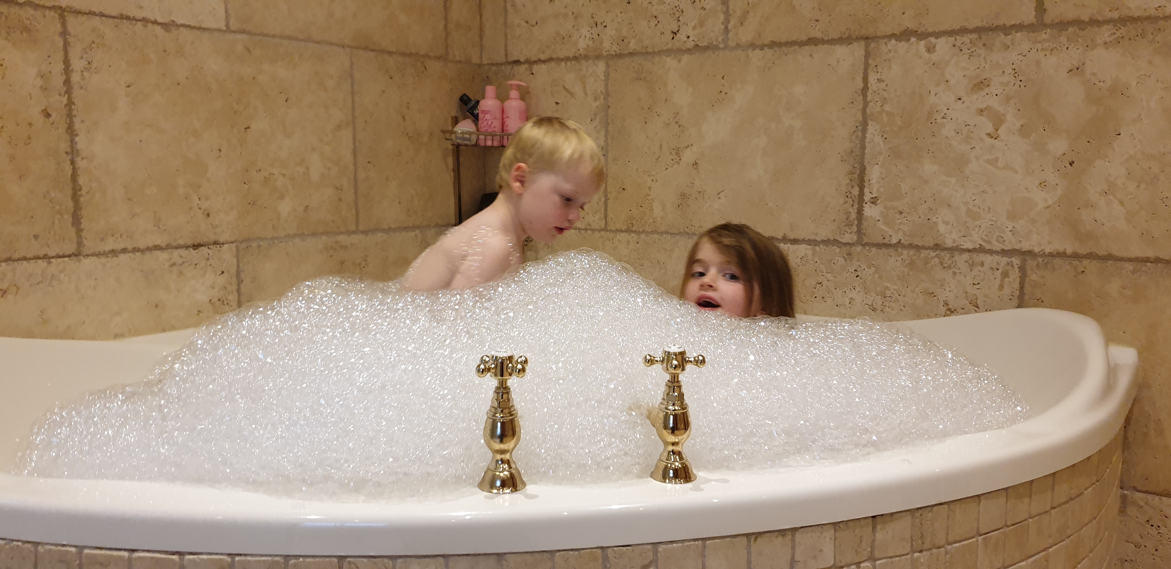 Full image of John and Annabel in a very bubbly bath.