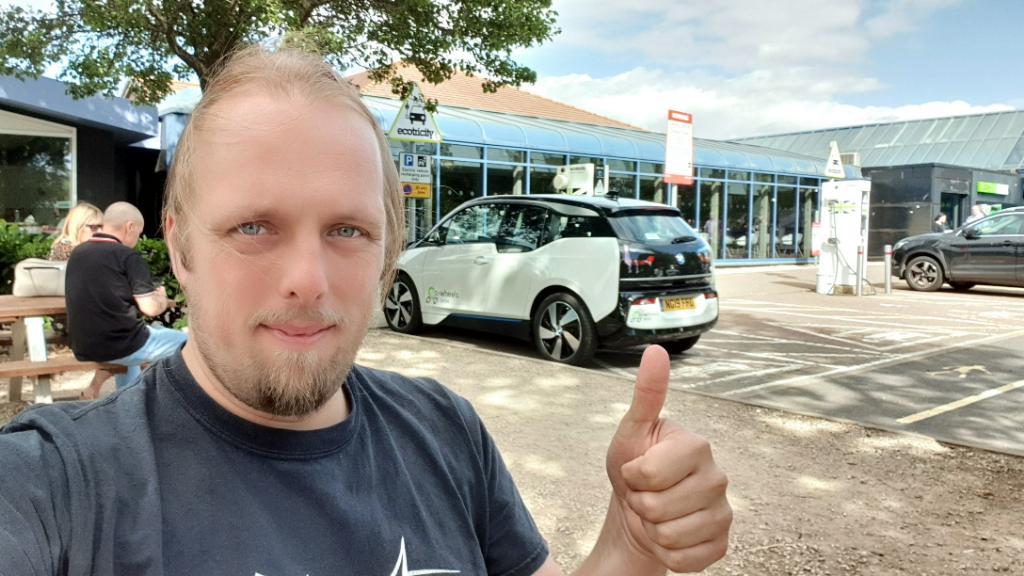 Full image of Dan and an eV at a charging point