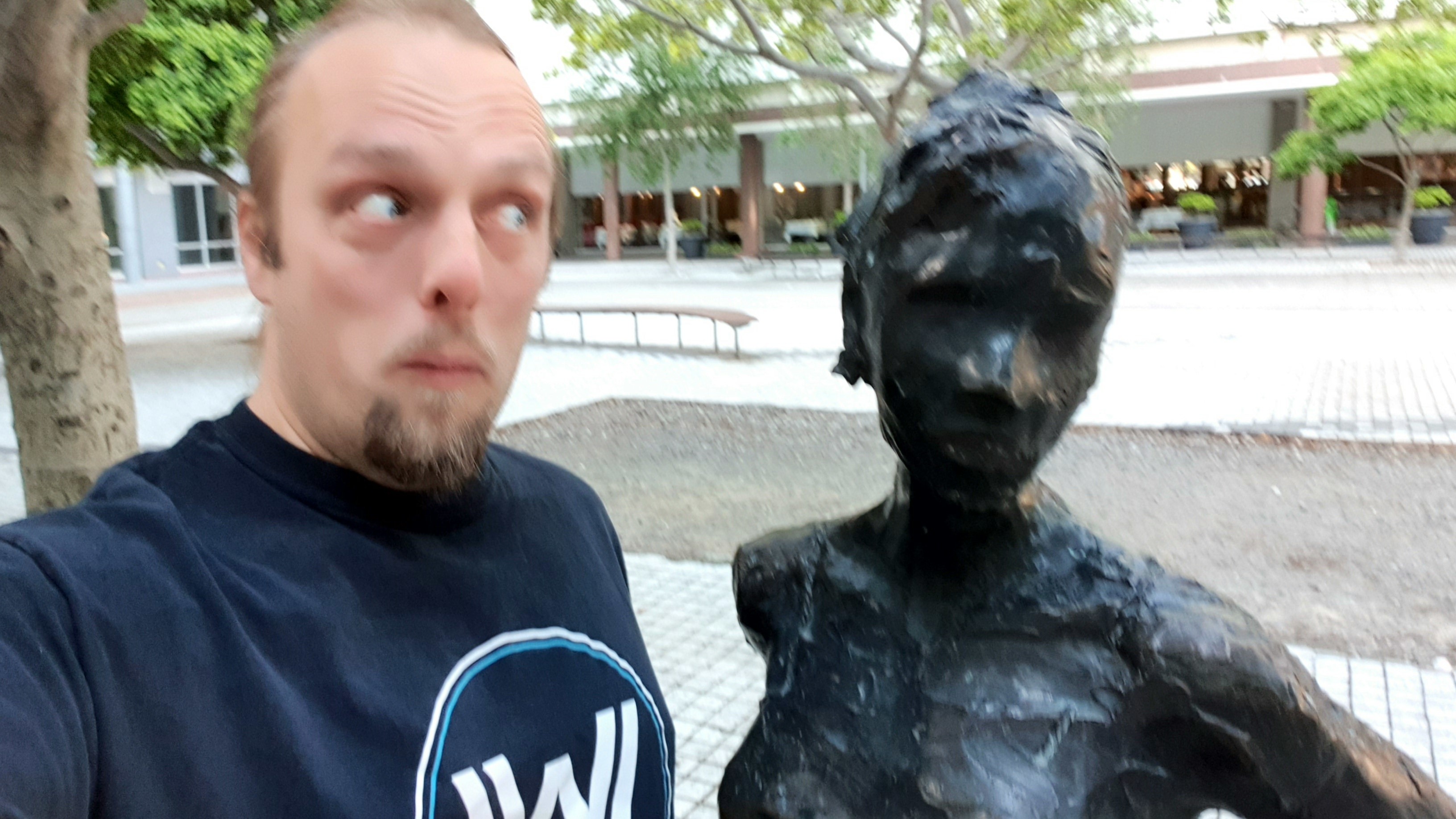 Full image of Dan with a statue at the GZ