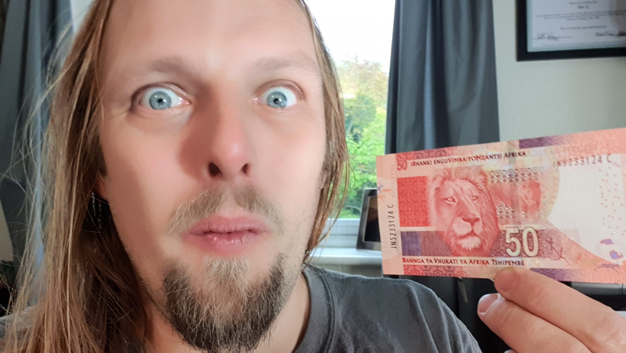Full image of Dan with a 50 South African Rand note.
