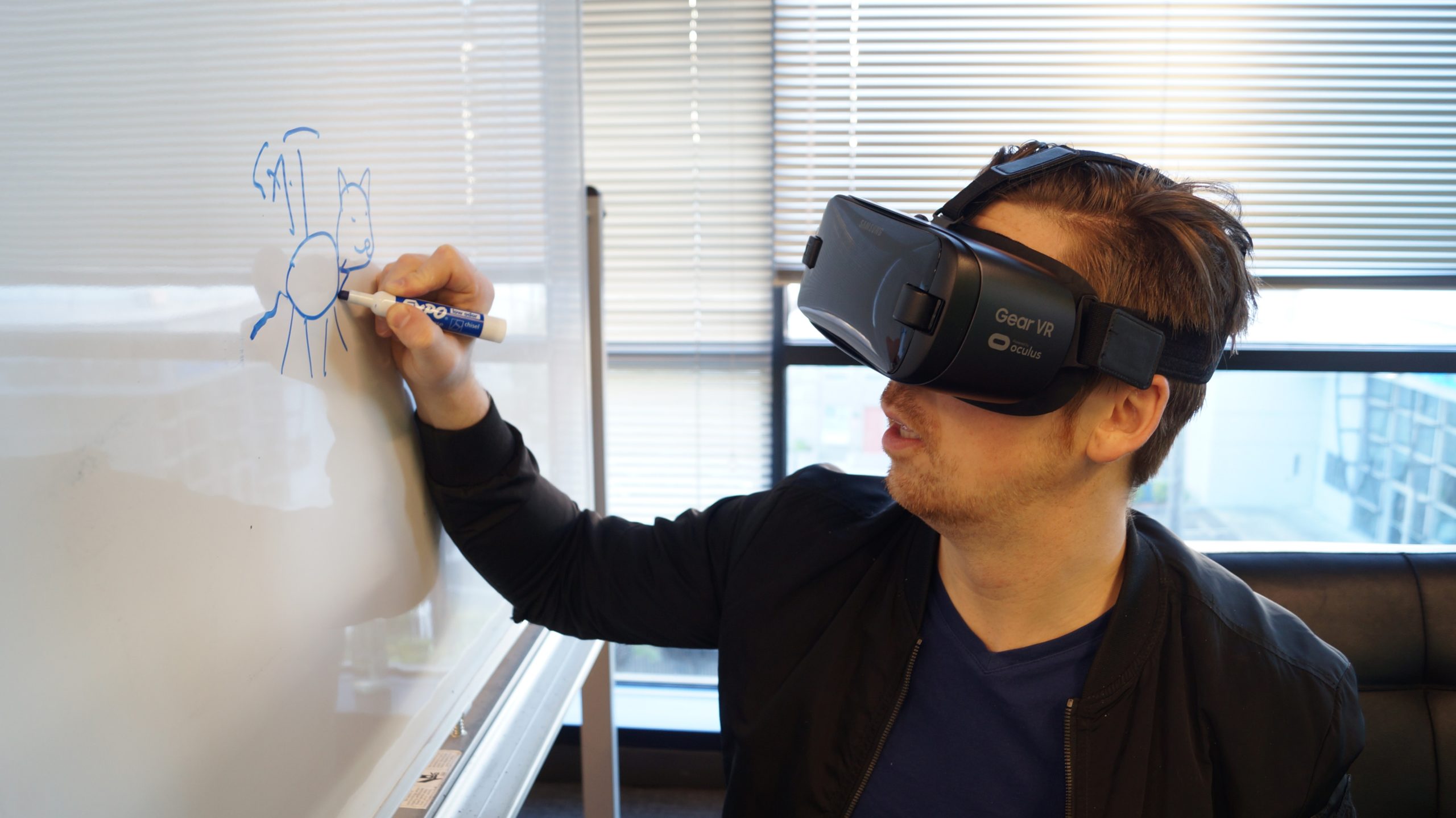 Full image of A man wearing a VR headset while writing on a whiteboard.