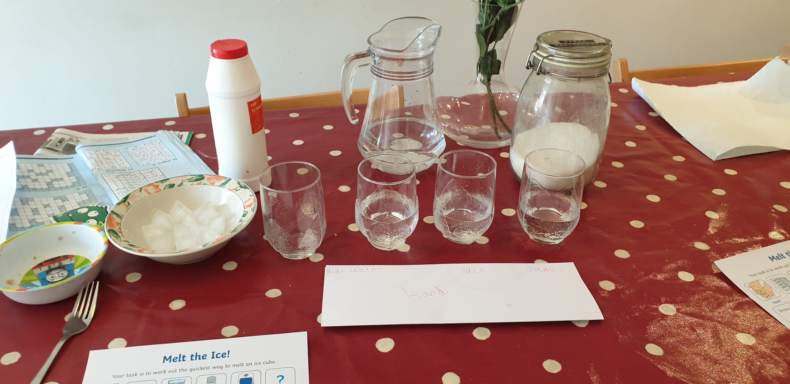 Full image of Bowl of ice, glasses of water, salt and sugar supplies.