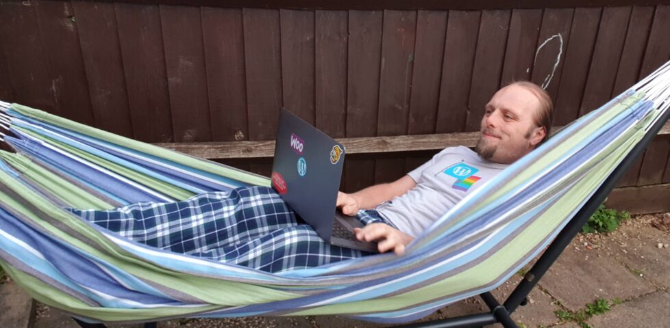 Dan in a video meeting, in a hammock.