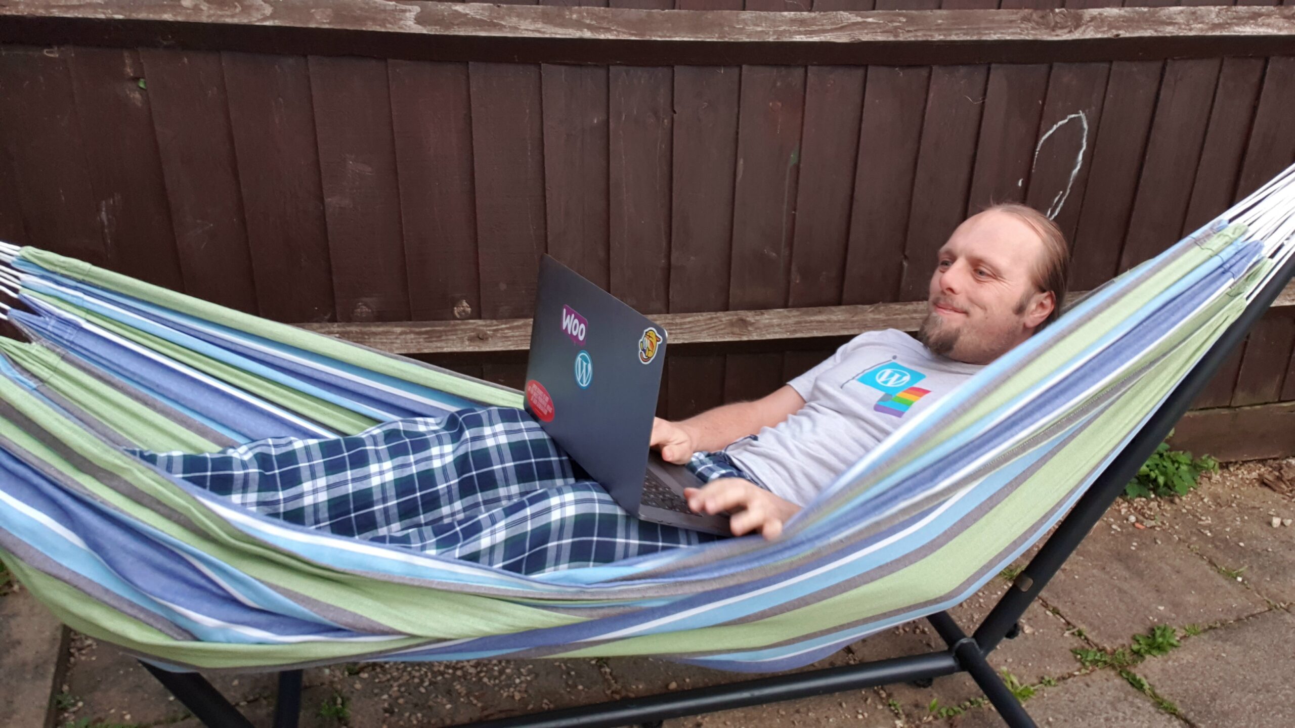 Full image of Dan in a video meeting, in a hammock.