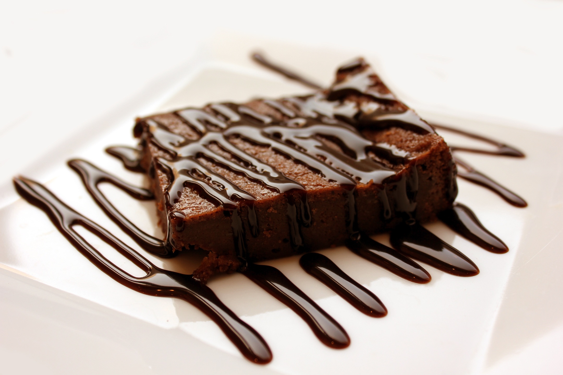 Full image of Chocolate brownie with melted chocolate sauce.
