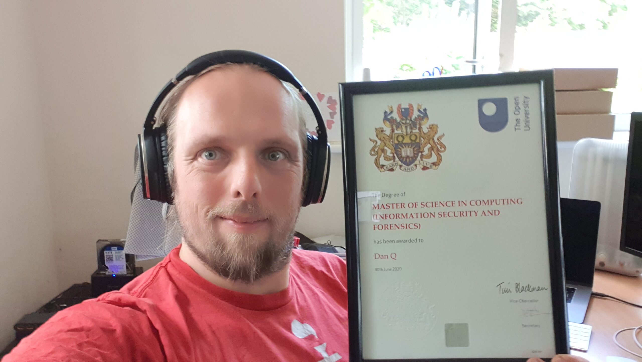 Full image of Dan with his Masters Degree certificate (Master of Science in Computing: Information Security and Forensics)