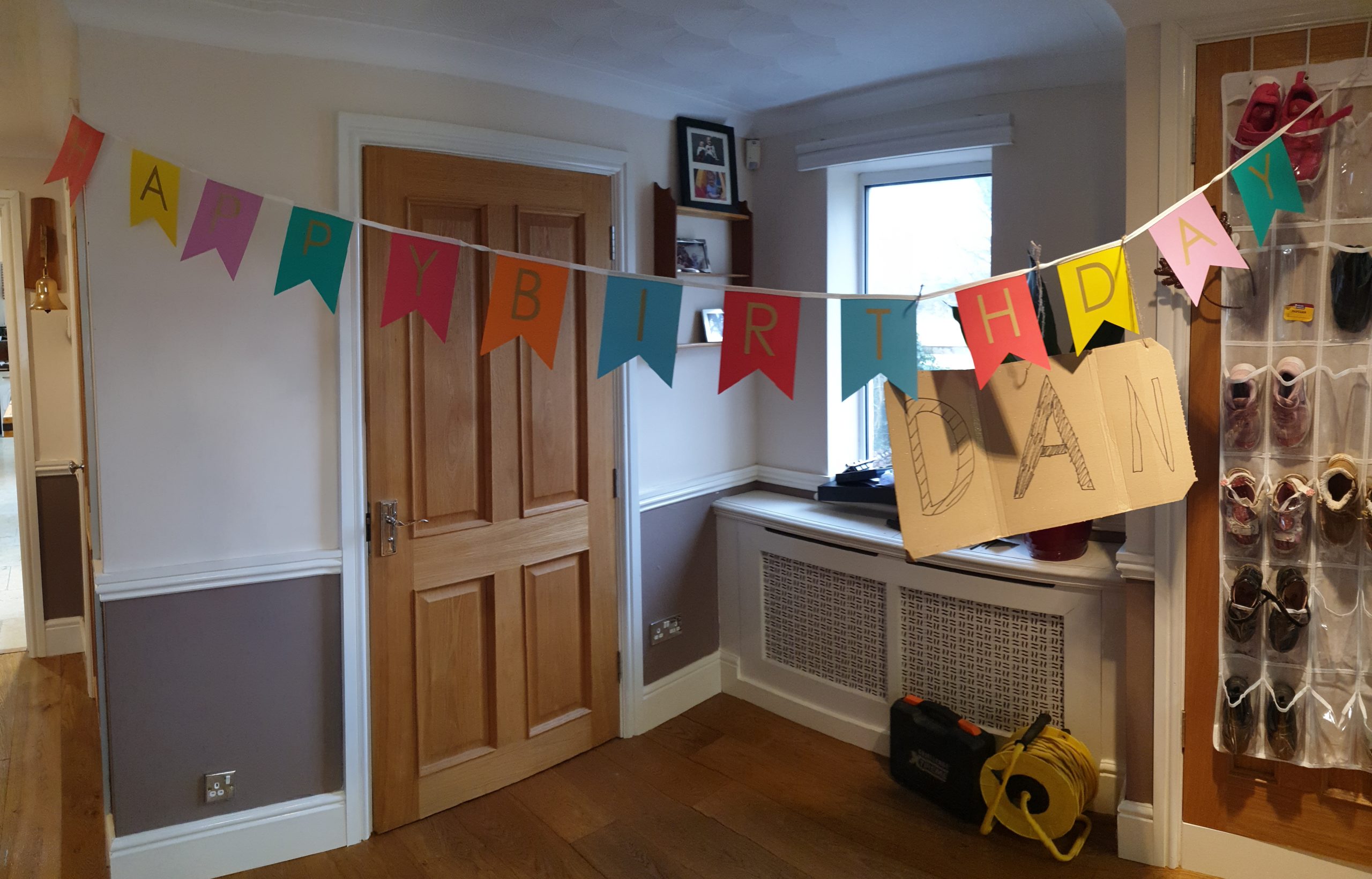 Happy Birthday banner with handwritten cardboard "Dan" sign hung underneath.