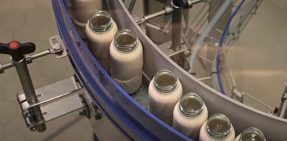 image captionThis image from Coca-Cola's filling line gives a clear view of the plastic cap still in use