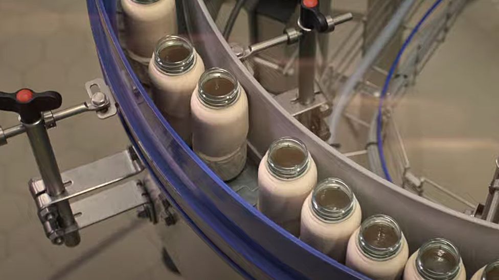 image captionThis image from Coca-Cola's filling line gives a clear view of the plastic cap still in use