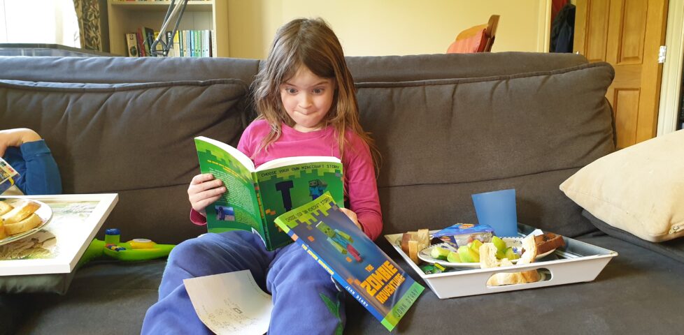 Annabe enjoying Choose Your Own (Minecraft) Story books.