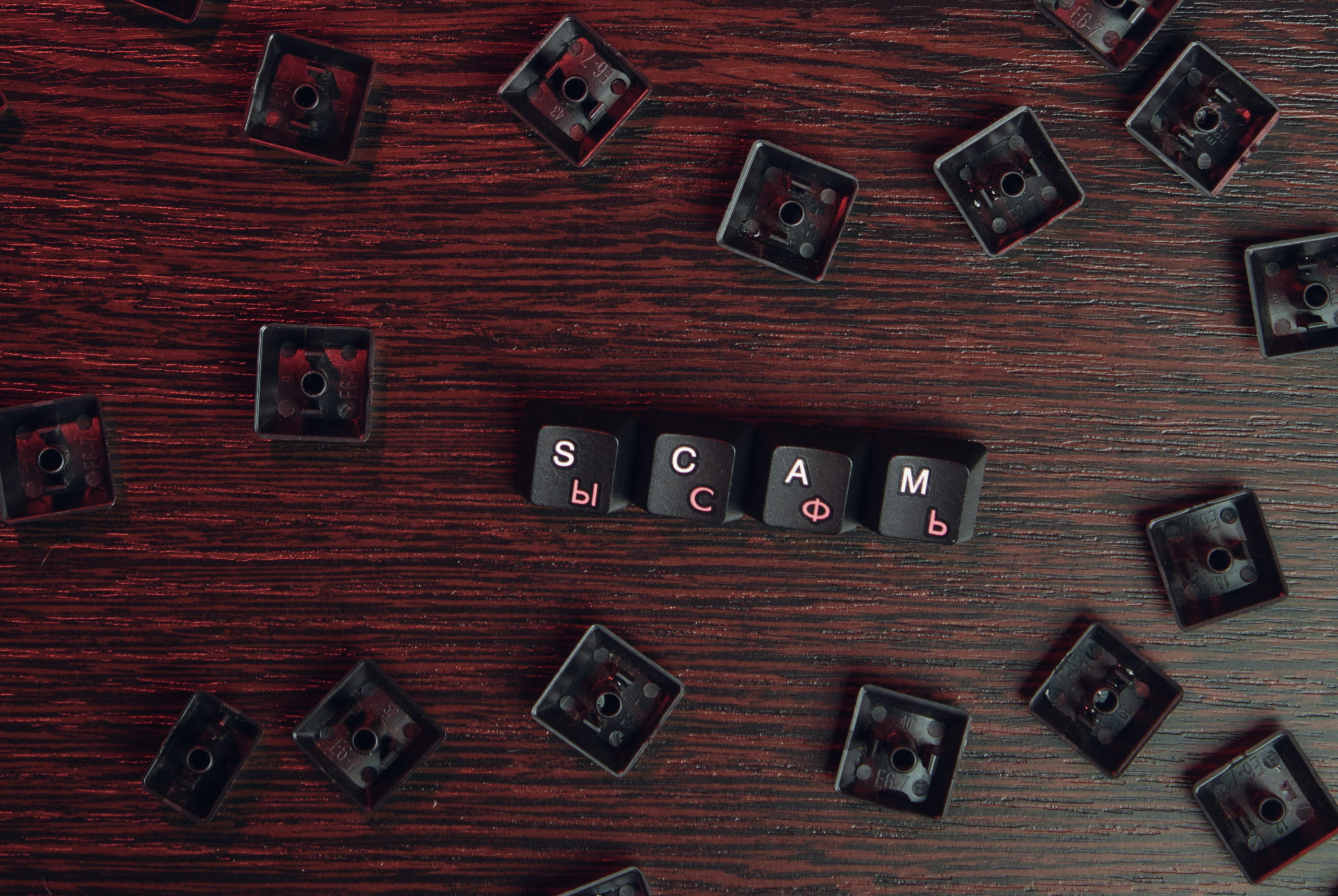 Full image of "SCAM" spelled out using keycaps from a cyrillic keyboard. Photo by Mikhail Nilov from Pexels.