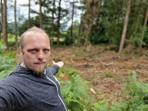 Dan in front of a felled section of forest.