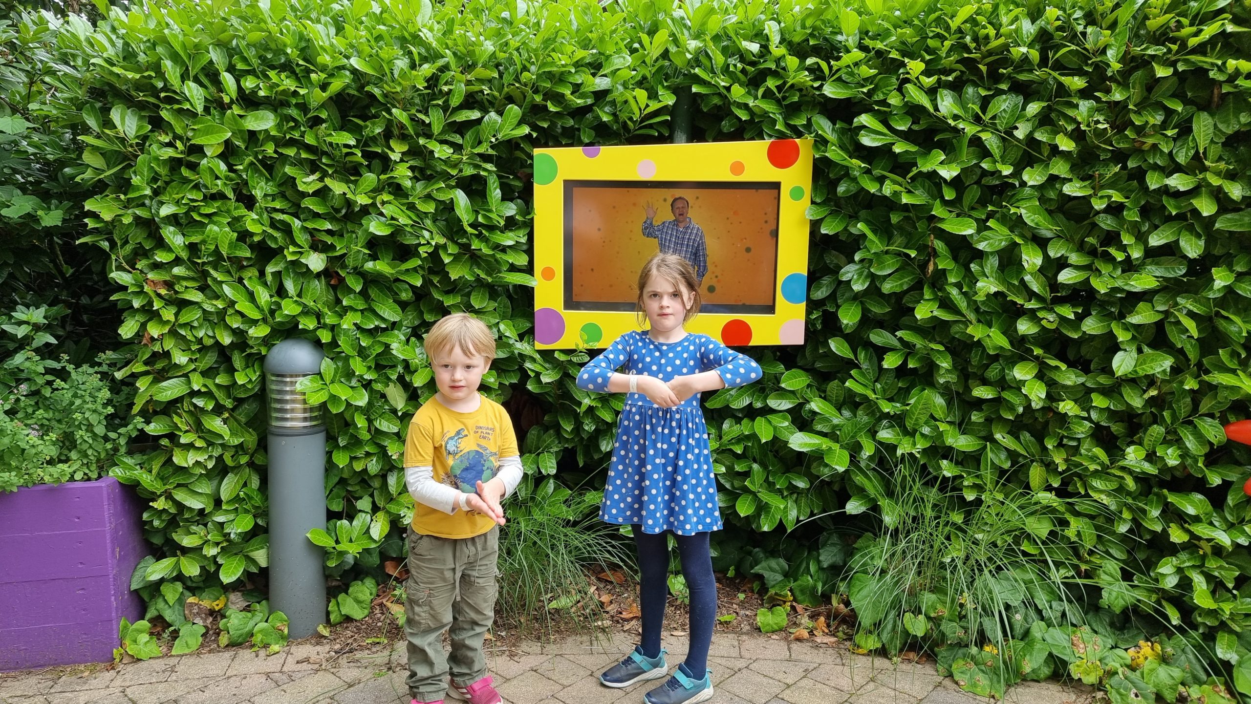 Full image of The kids learn from a Mr. Tumble screen.