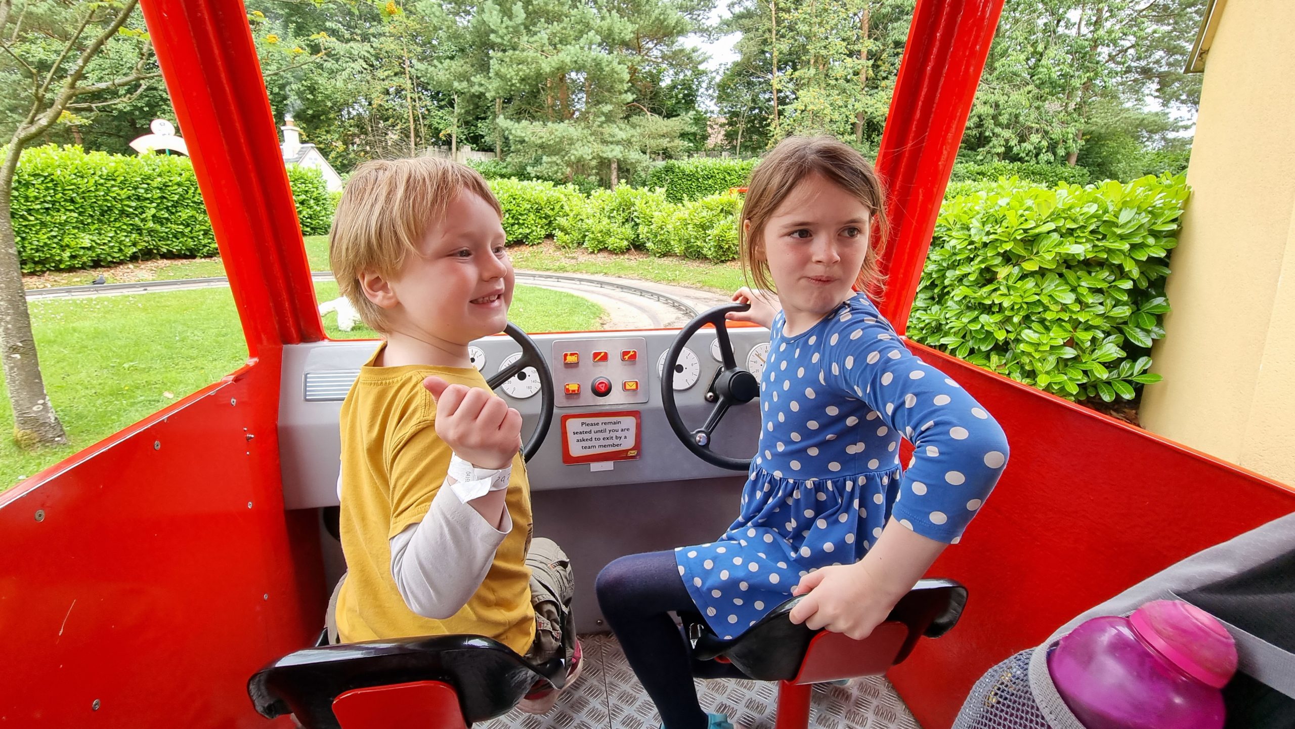 Full image of The kids drive through the Postman Pat ride.