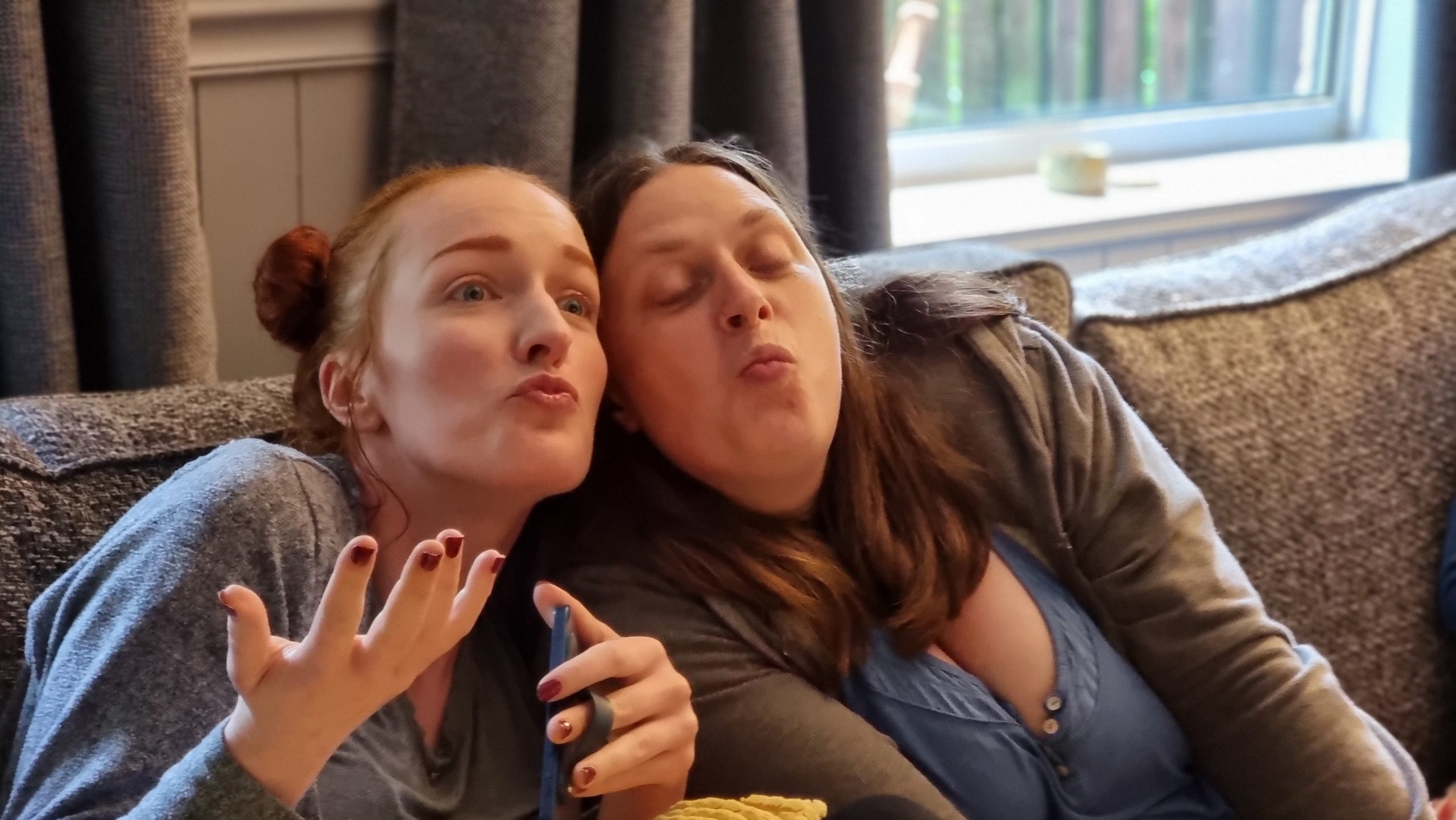 Full image of Sarah and Ruth pull strange pouty faces together.