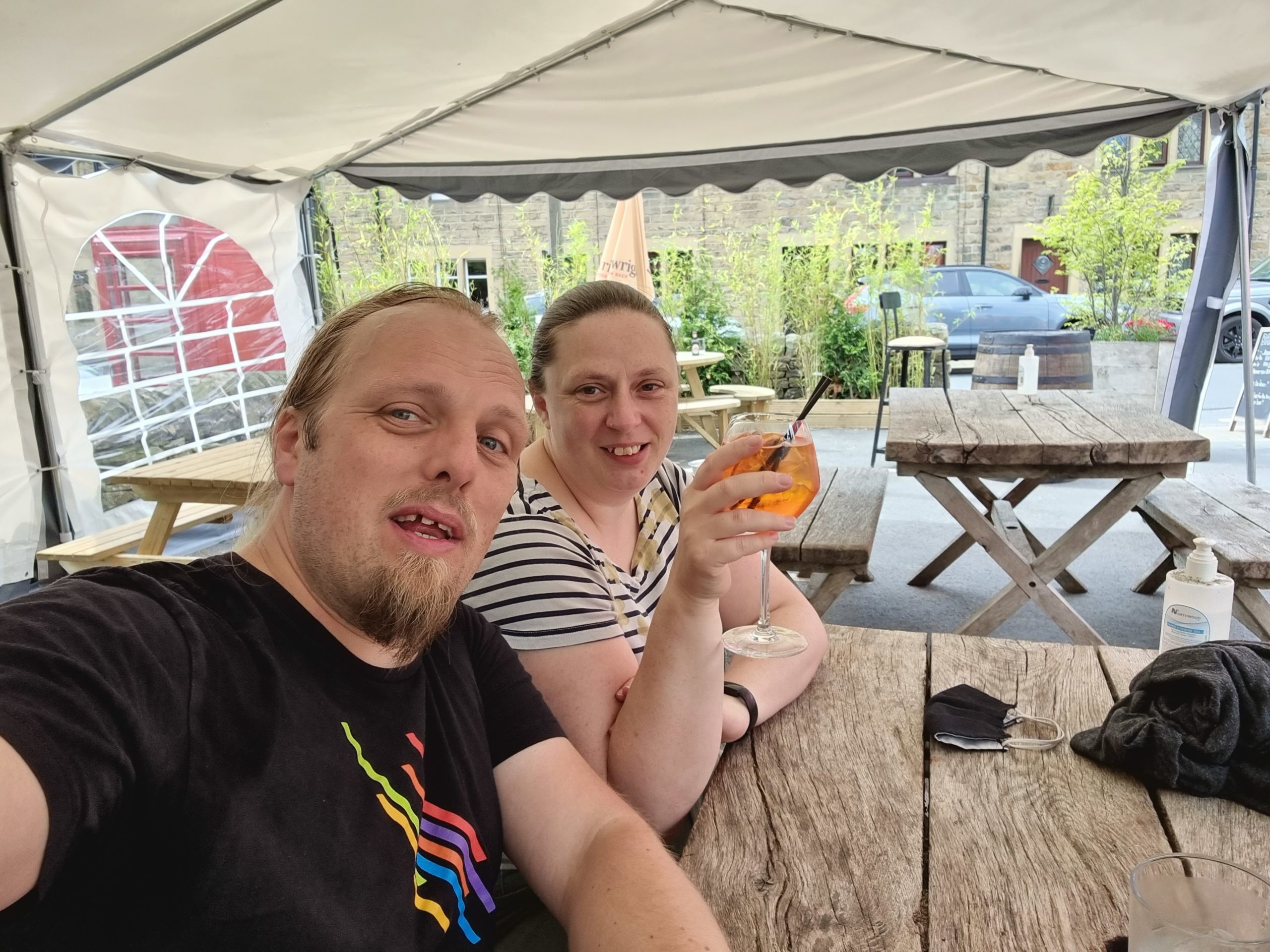 Full image of Dan and Ruth enjoy cocktails in a beer garden.