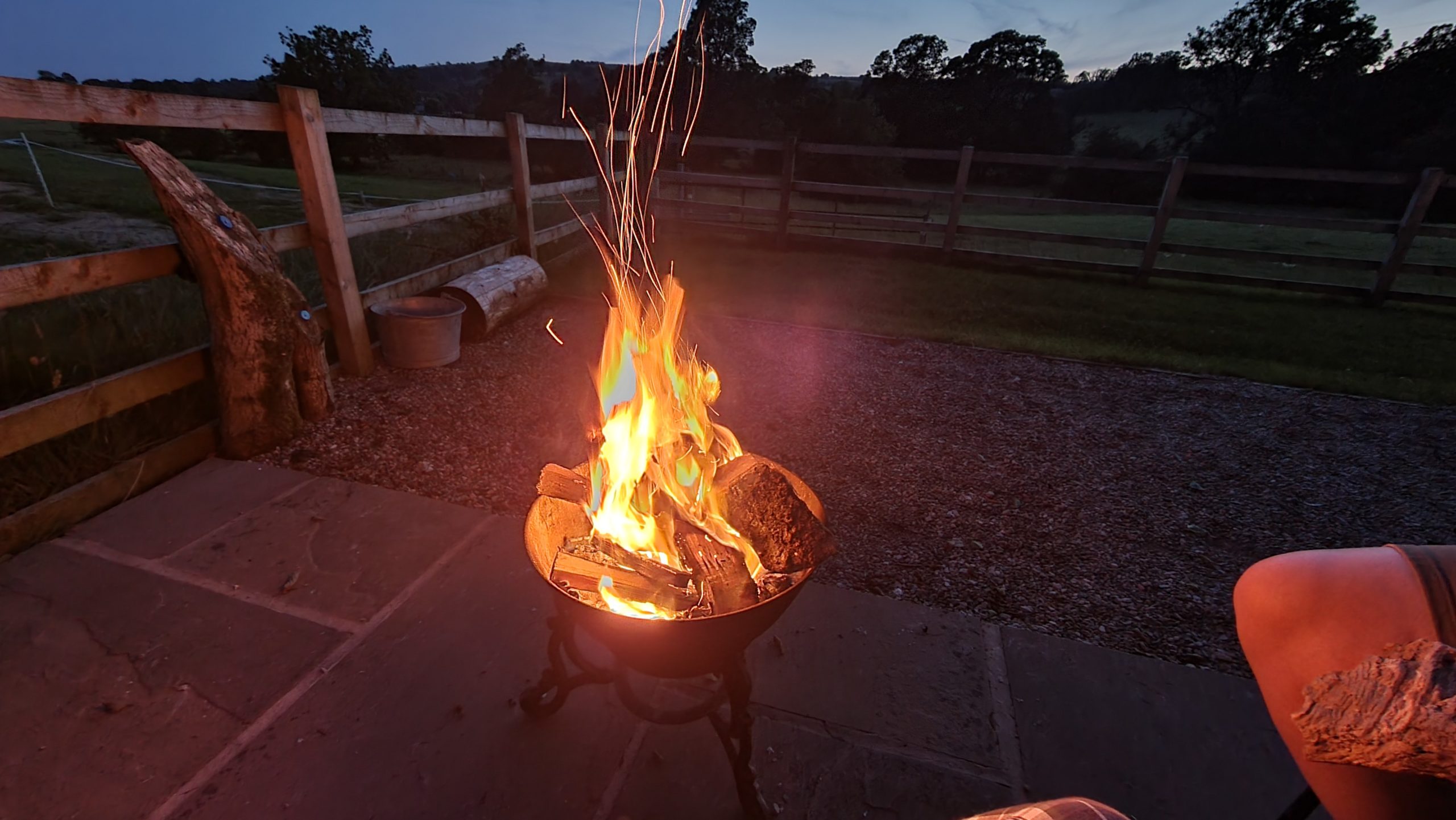 Full image of A fire pit rages and sparks.