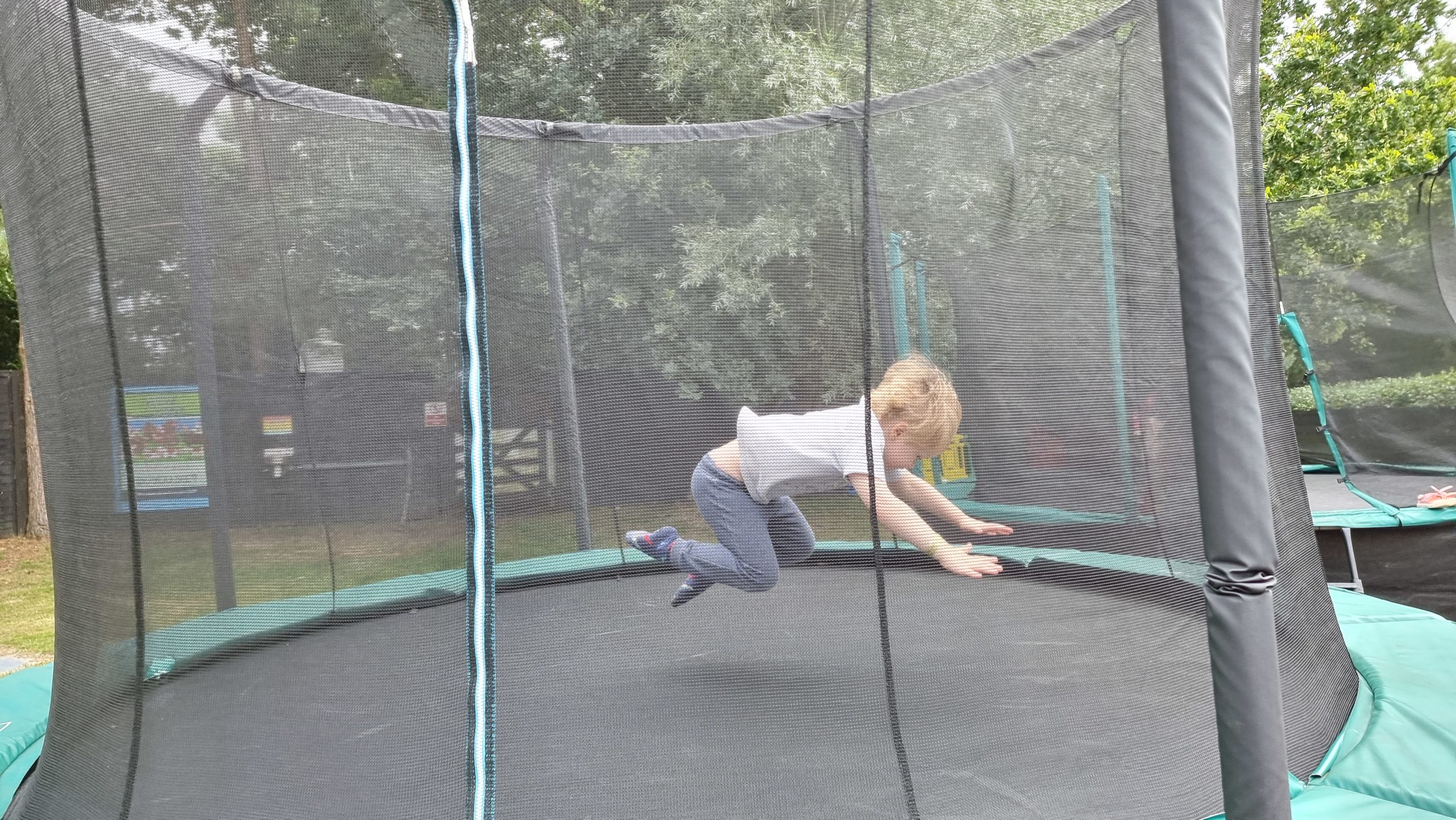 Full image of A boy dives onto a trampoline.