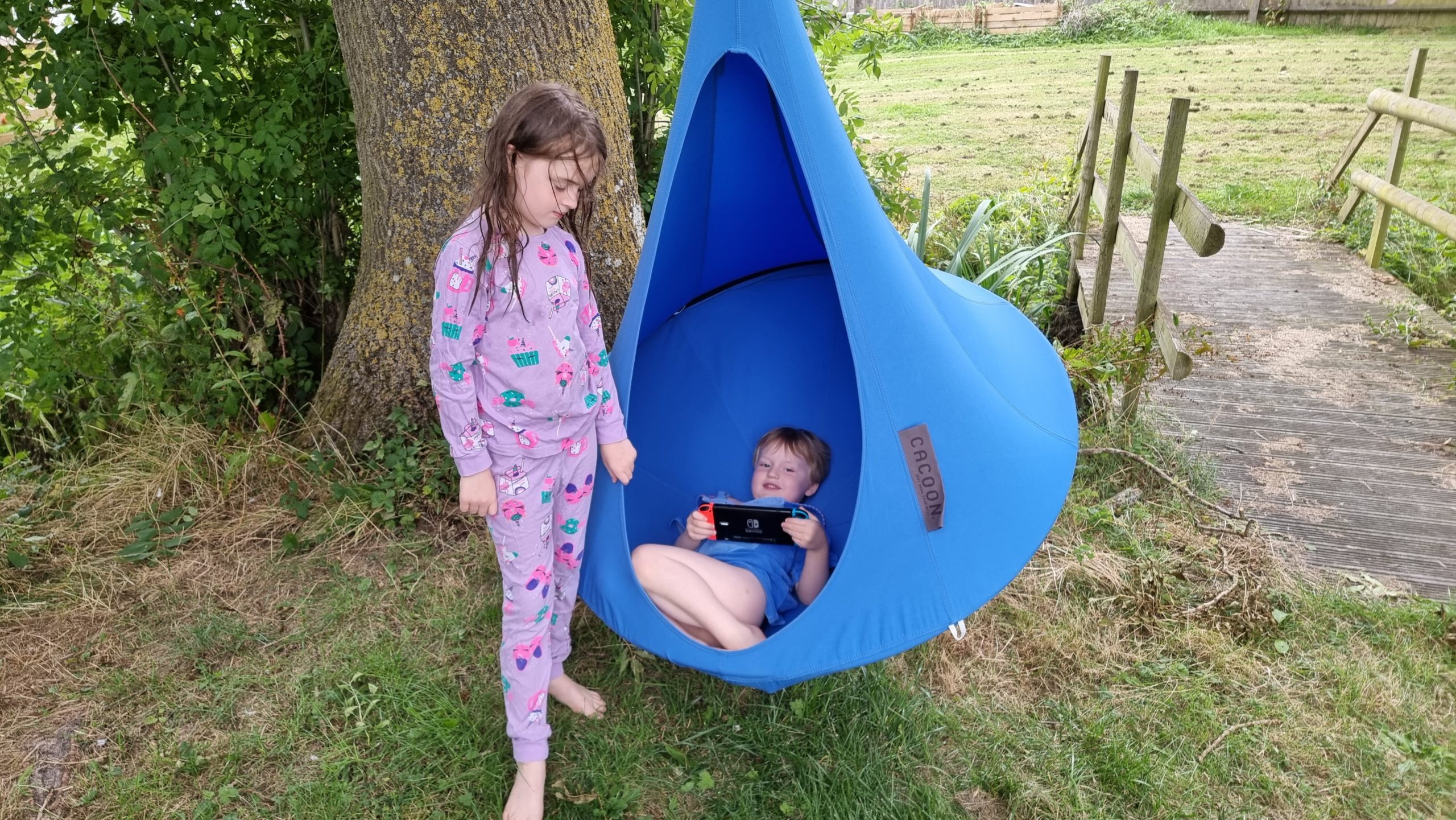Full image of The kids play switch while they hang in a 'nest swing'.