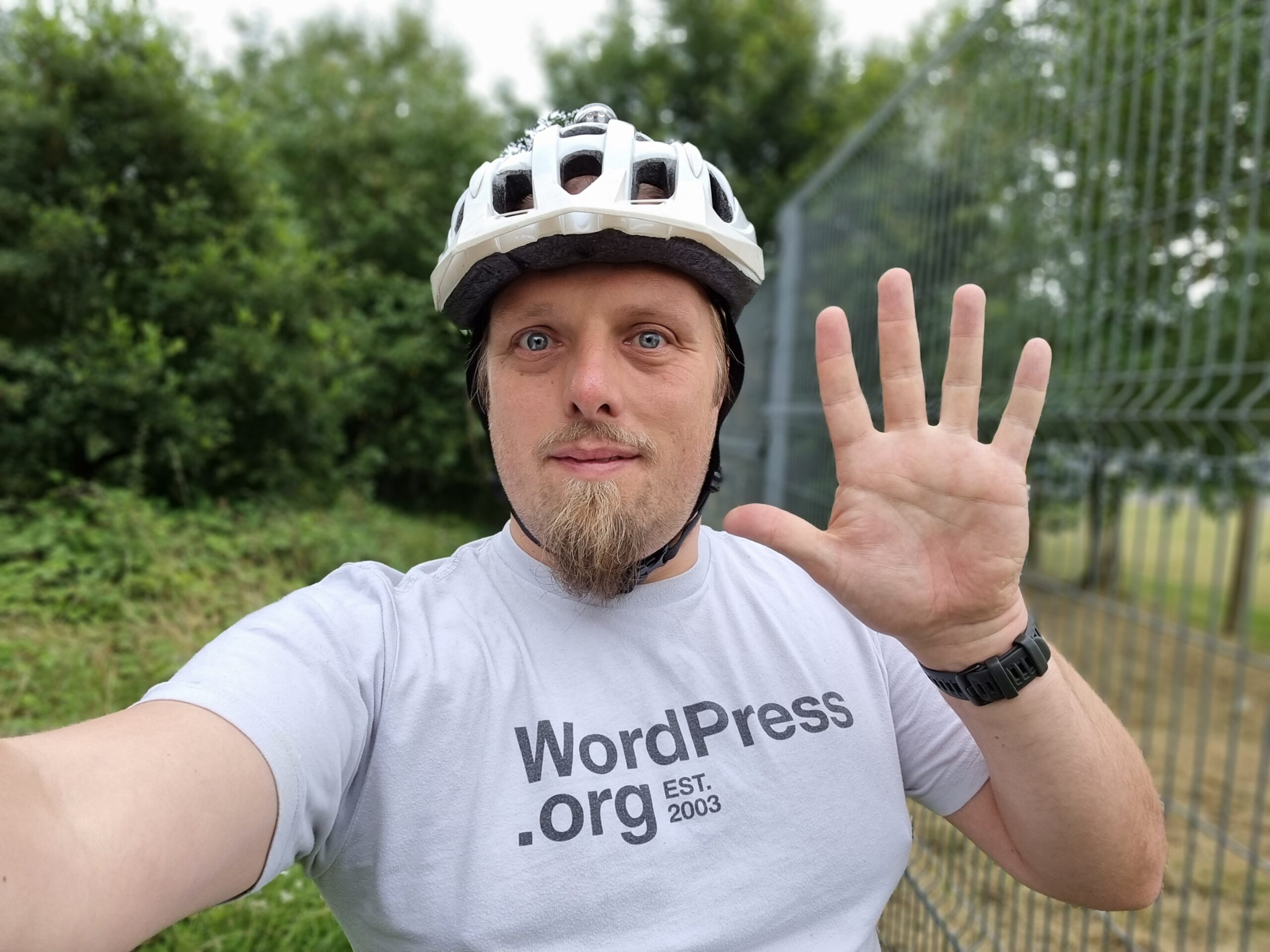 Full image of Dan, on his bike, waves.
