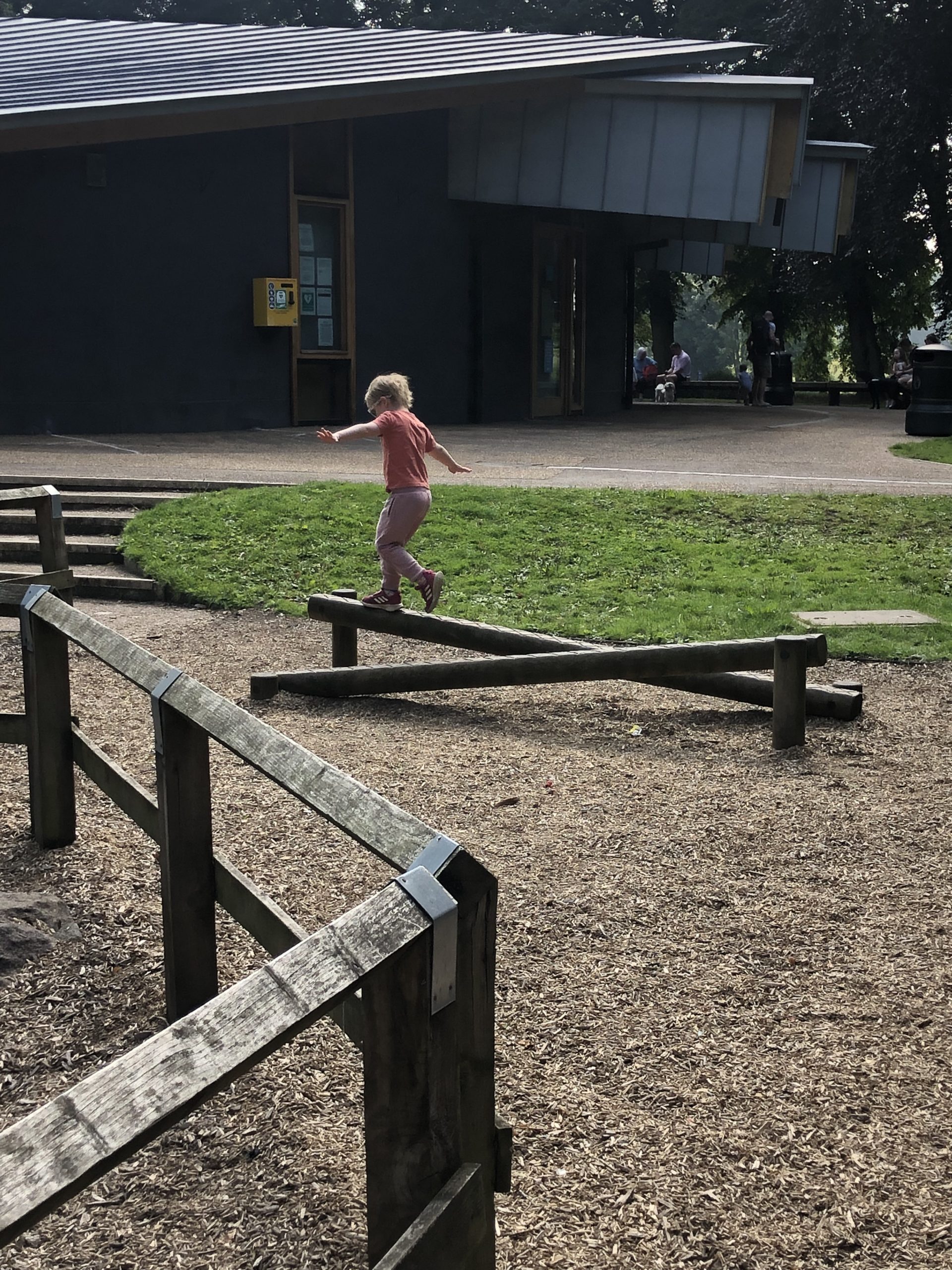 Full image of Boy balancing on a beam at a park.