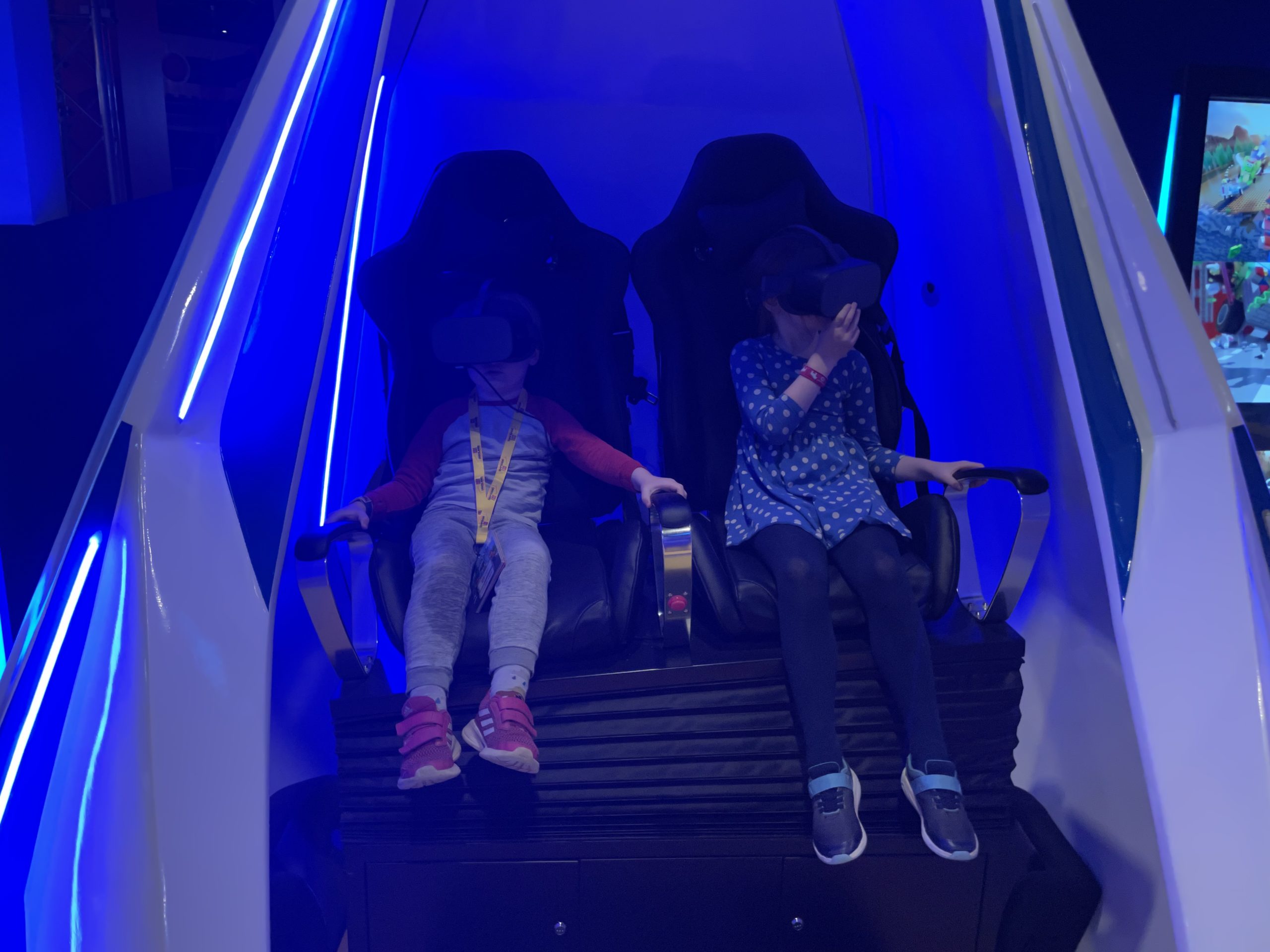 Full image of Children in a VR motion simulator.