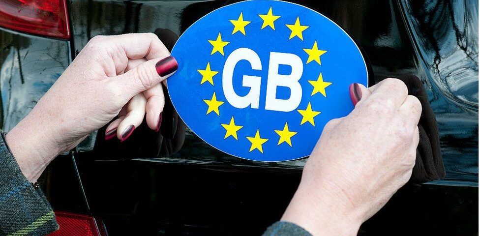 GB sticker being affixed to a car.