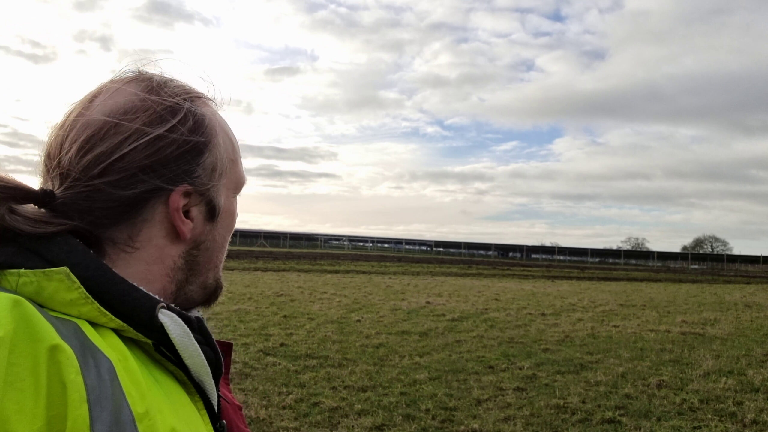 Full image of Dan looks towards a solar farm