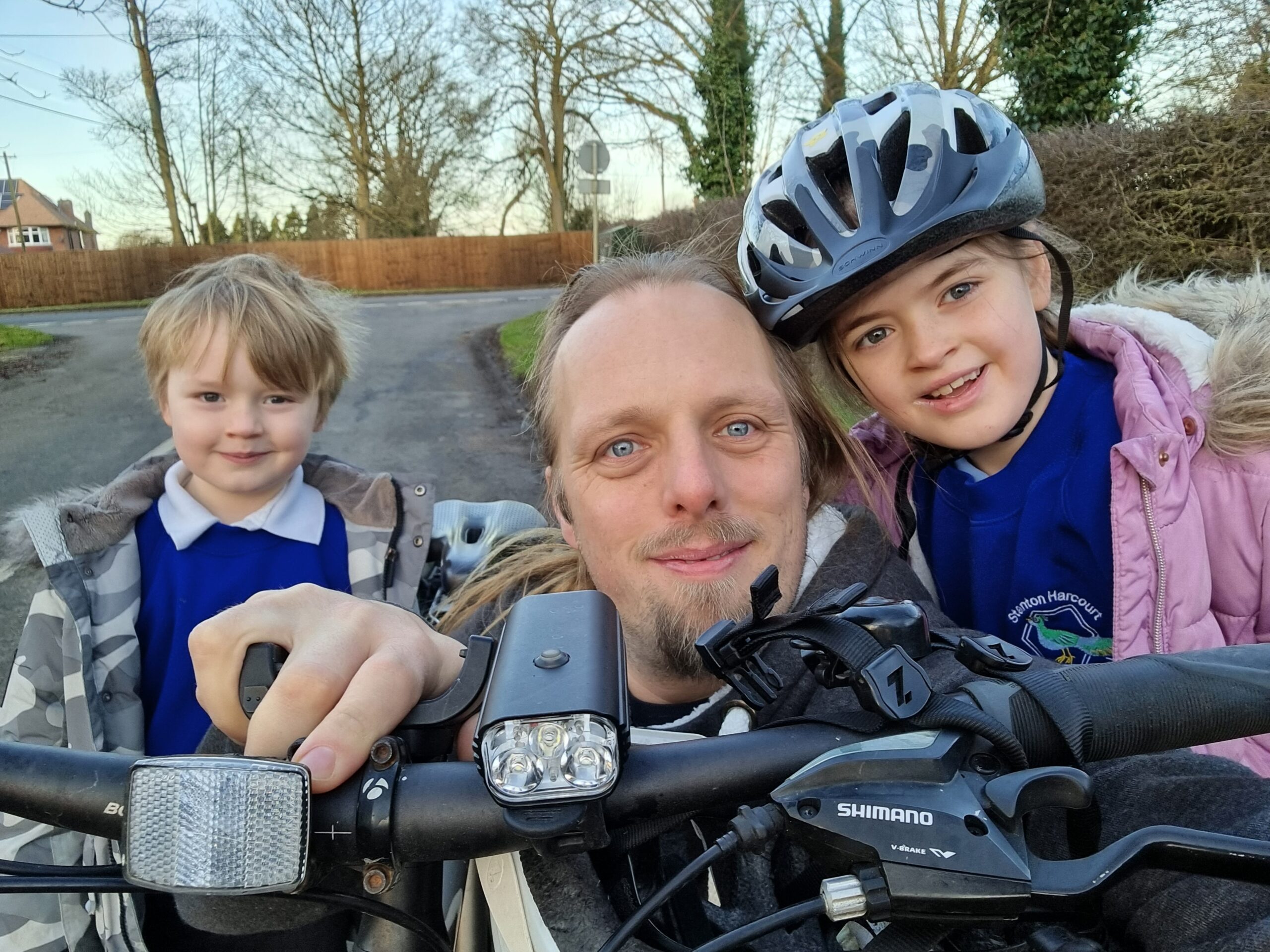 Full image of Dan with the kids and his bike, on the way to school.