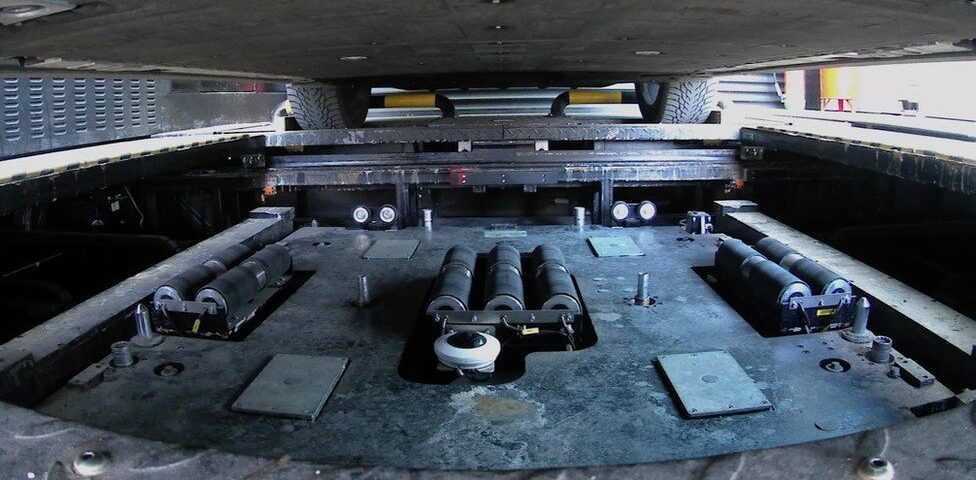 Underside of a car with a removable battery.