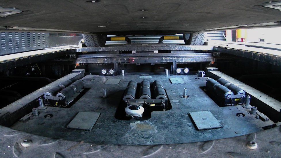 Underside of a car with a removable battery.