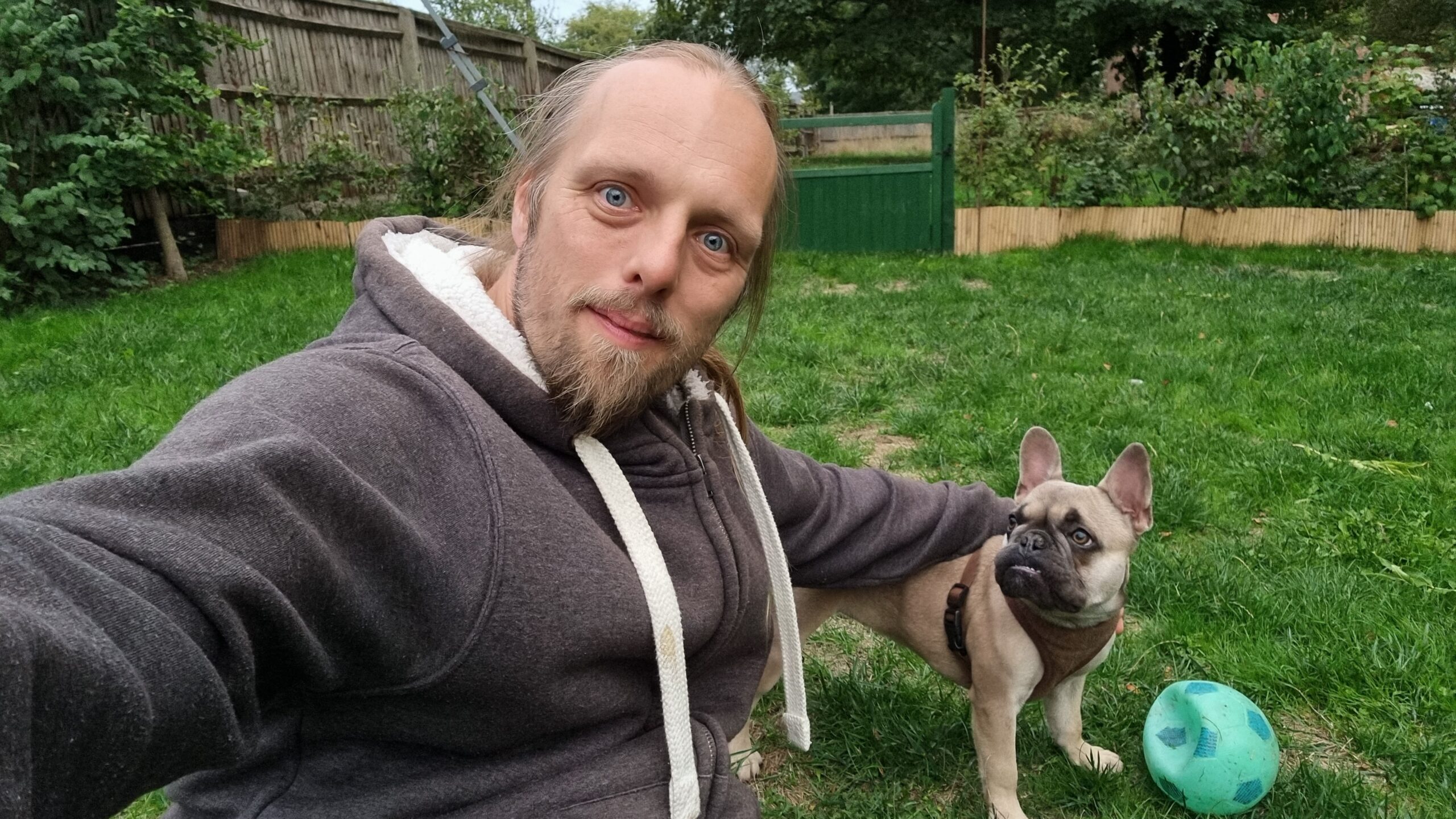 Full image of Dan with the dog, in the garden.