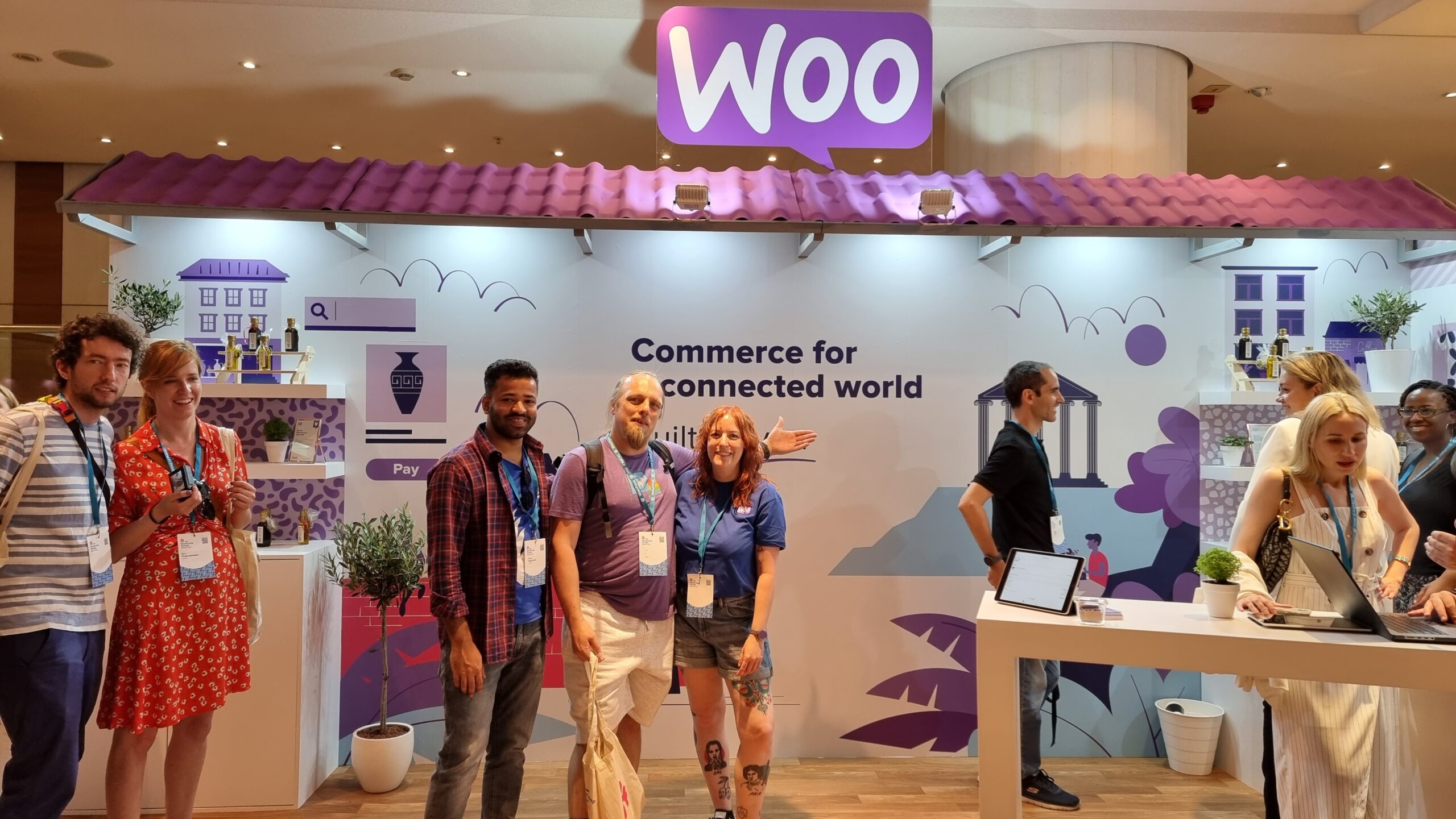 Full image of A "Woo" booth, staffed with a variety of people, with Dan at the centre.