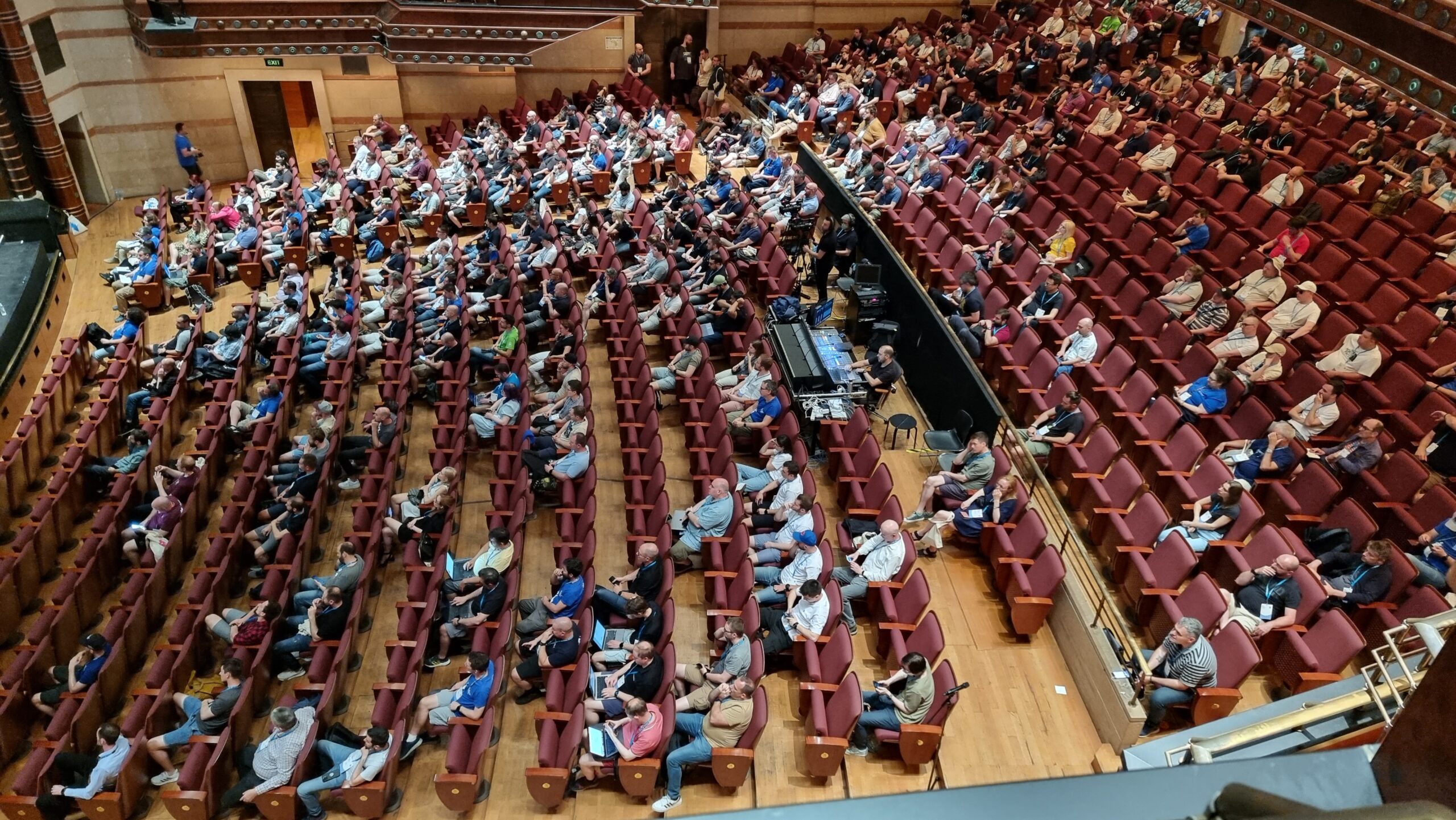 Full image of A large audience of a few hundred people, seen from above, facing left.