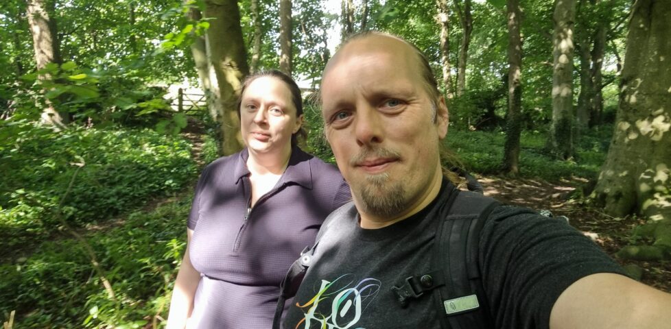 Ruth and Dan walking through a lush temperate forest.
