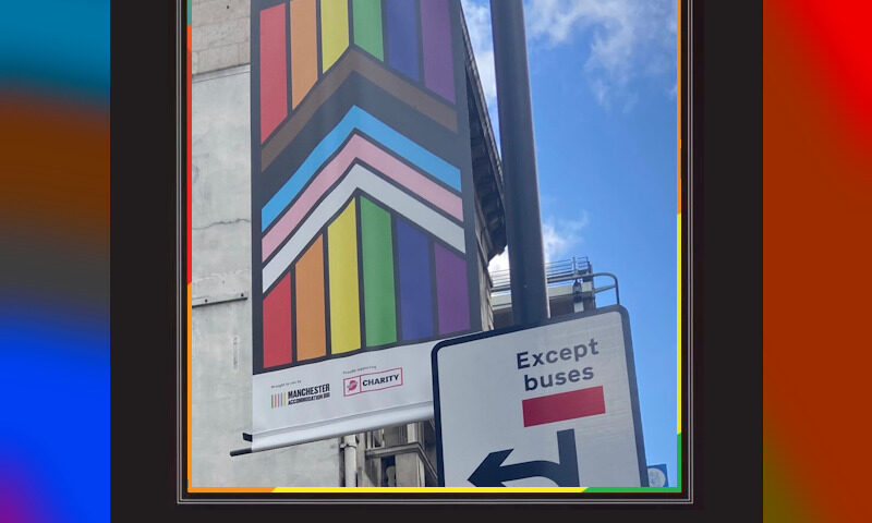 Motivational poster showing a photograph from a Manchester street. A Pride flag banner is hanging from a post with the words "everybody welcome" at the top. Nearby, attached to the same post, a road sign has the words "except buses". The poster is captioned with the word "inclusivity" (in pride colours), and subcaptioned "the 'B' is not for Buses". The joke is that the 'B' in LGBTQ+ stands for 'bisexual' and not 'buses', although of course the real meaning of that street sign is to ban everybody from driving straight ahead except buses, so the joke isn't perfect.