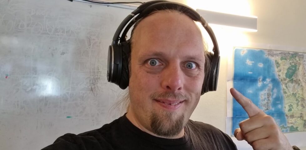 Dan pointing to a pair of wireless over-ear headphones that he's wearing.