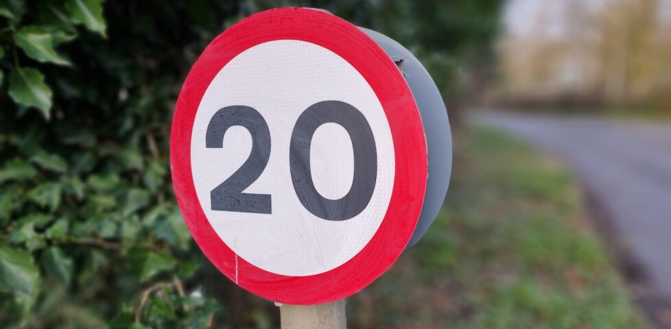 A 20mph "repeater" speed limit sign around the corner from the cache location.