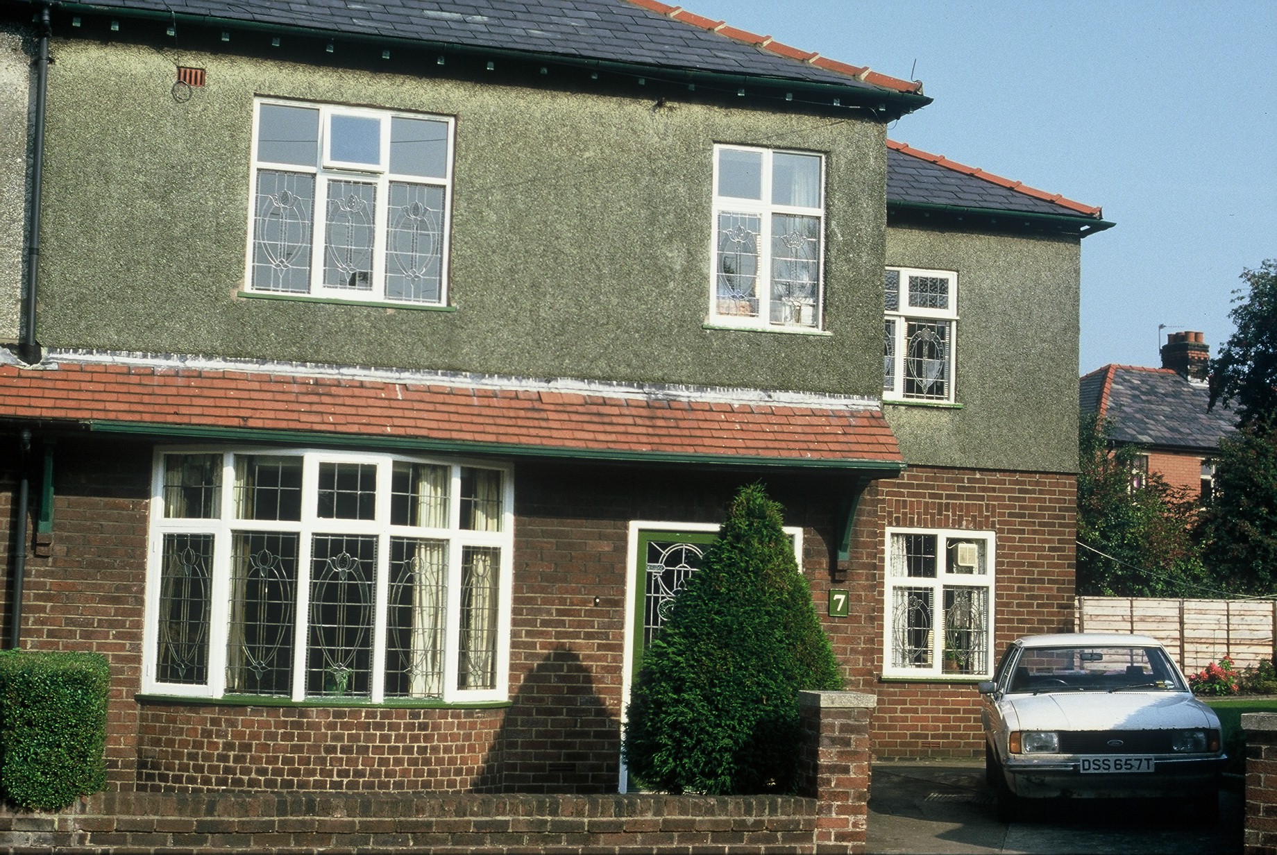 Full image of A partially-pebbledashed house.