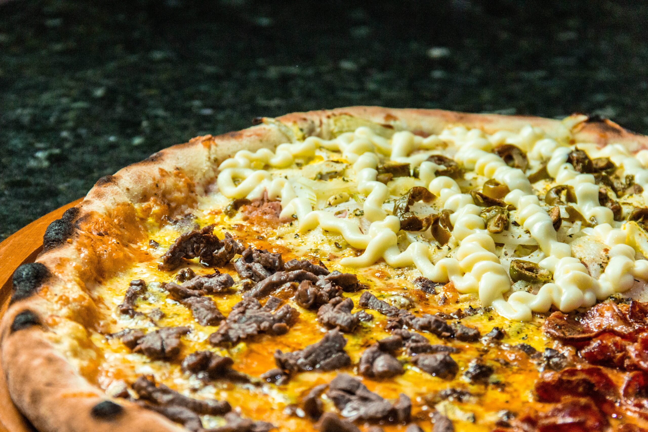 Full image of Close-up of a pizza whose four quarters contain four different toppings.