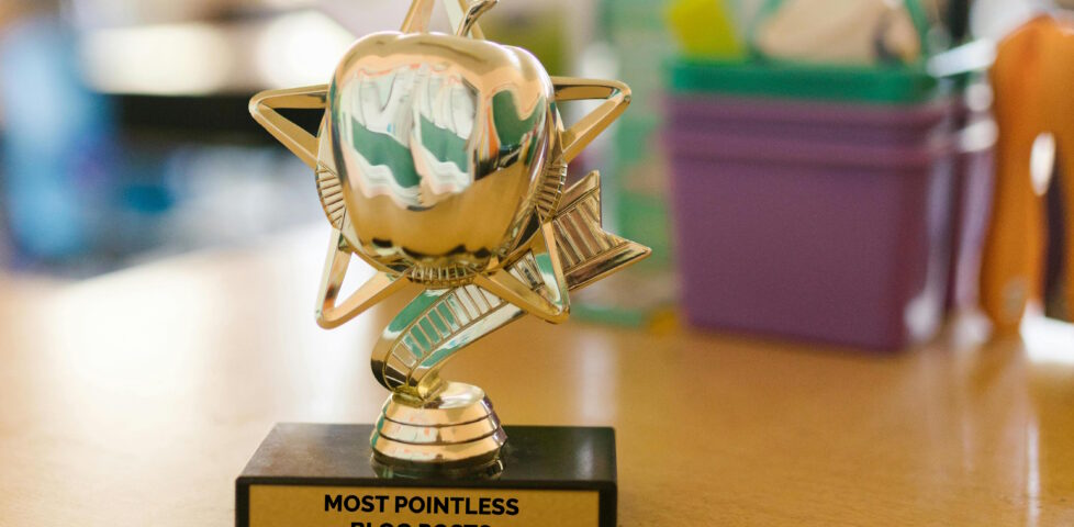 Trophy on a desk with the plaque "most pointless blog posts".