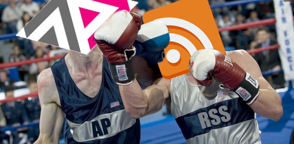 Photograph of a boxing match, but with the heads of the competitors replaced with the ActivityPub and RSS logos (and "AP" or "RSS" written on their clothes, respectively). RSS is delivering a powerful uppercut to ActivityPub.