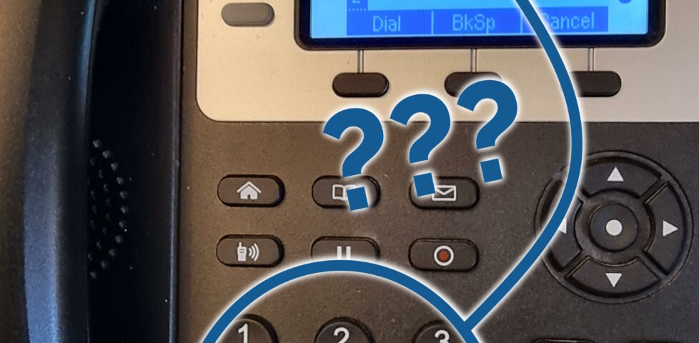 Modern desk telephone with an 01865 number (masked) and a keypad with letters on the buttons, 2=ABC through 9=WXYZ, with superimposed question marks between the two.