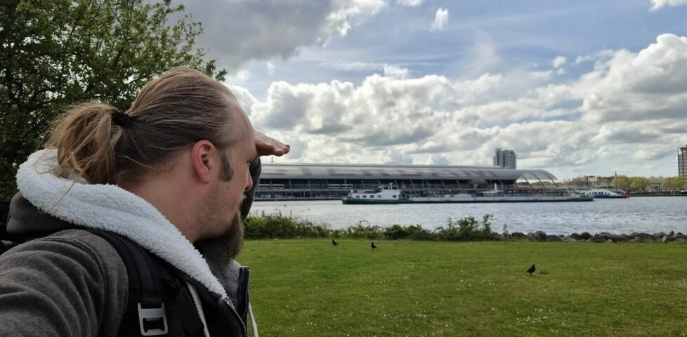 Dan puts his hand to his brow as he looks out to sea near Amsterdam.