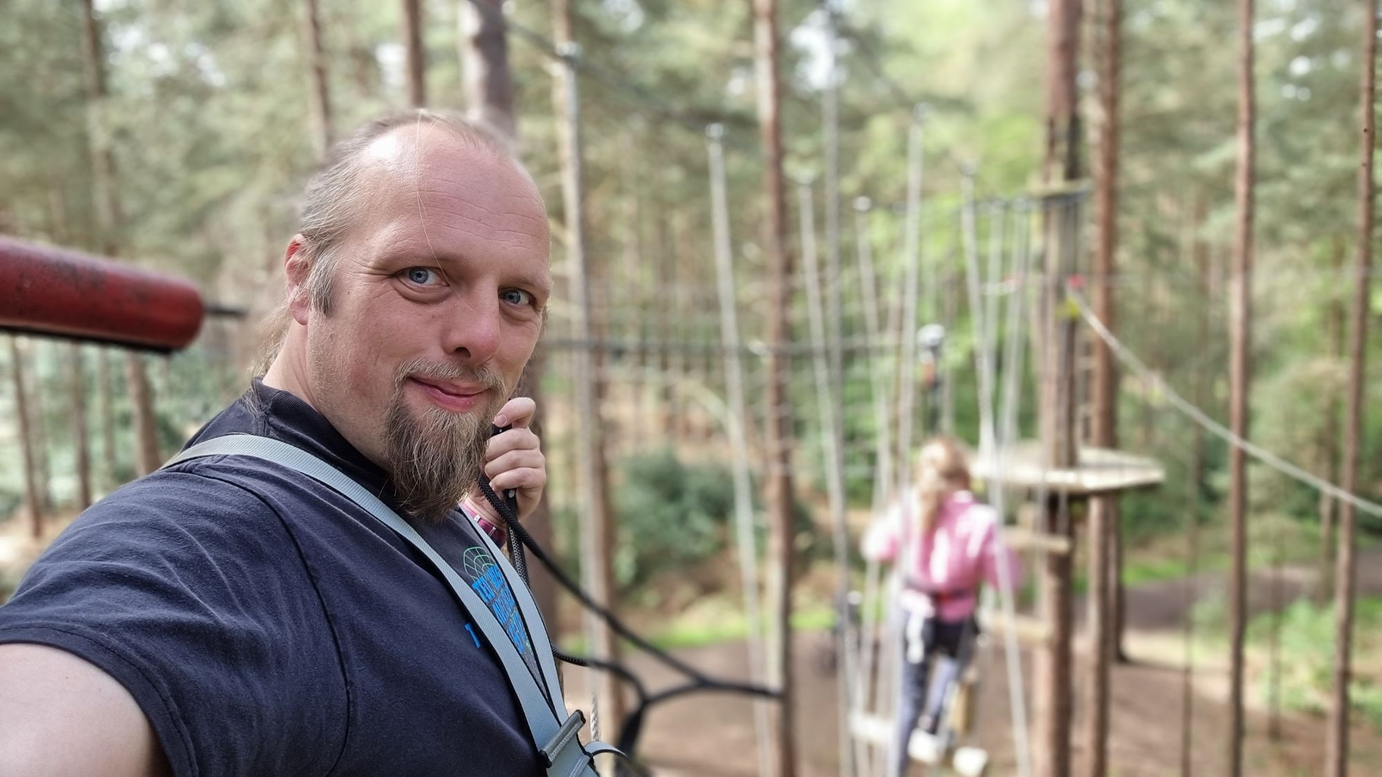 Full image of Dan takes a selfie from a high-ropes course, up a tree.