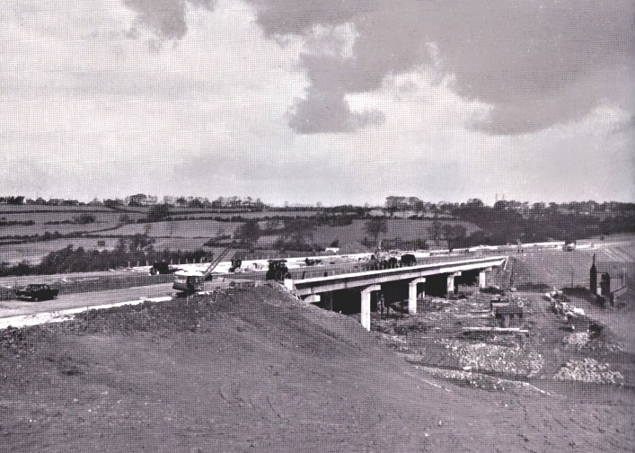 Full image of Monochome photograph showing construction of bridge support pillars.