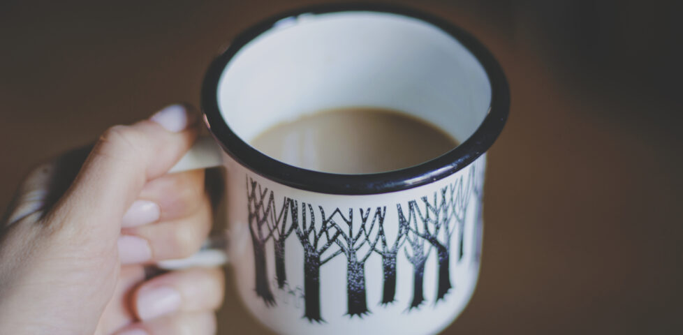 A mug of tea held by the handle.