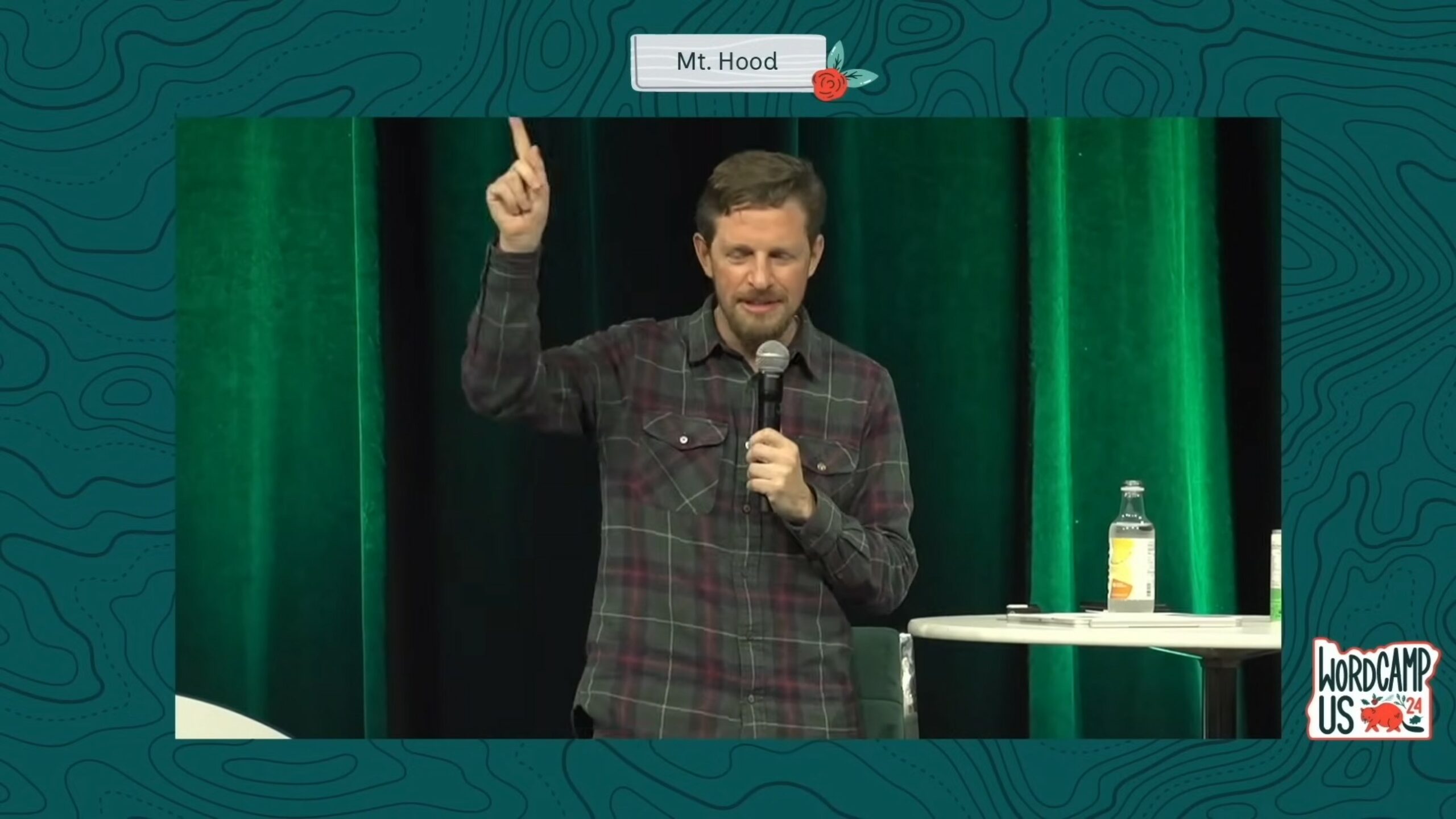 Full image of Matt Mullwenweg on stage at WordCamp US 2024, stating how he feels that WP Engine exploits WordPress (to great profit) without contributing back.
